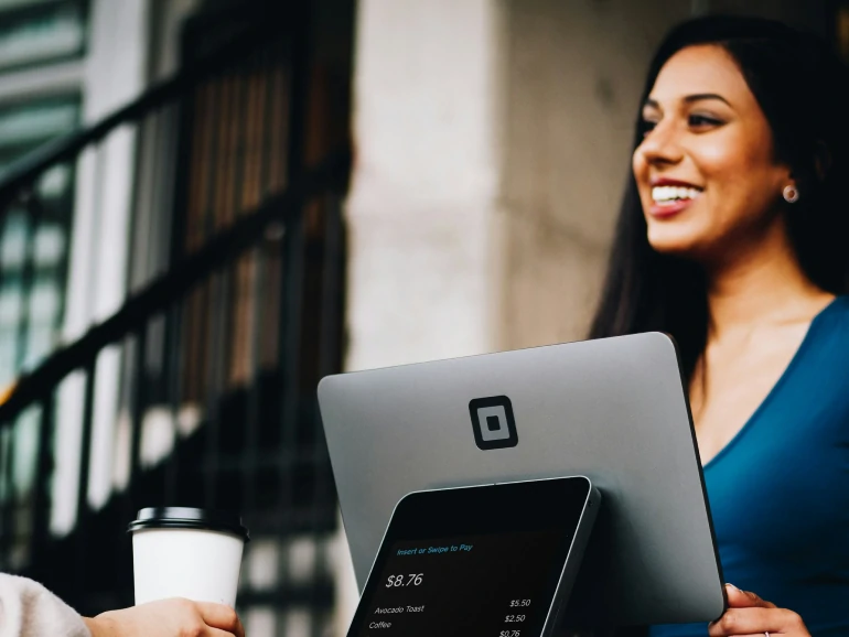 Pessoa em um balcão de pagamento conversando com a atendente do caixa